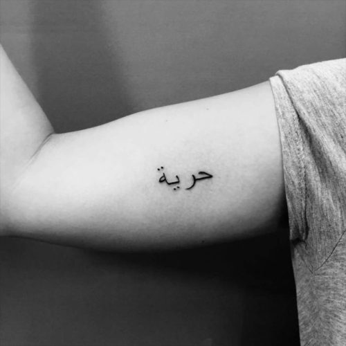 二の腕のアラビア語のレタリングタトゥー