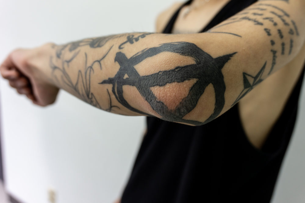 肘のアナーキーマークのタトゥー